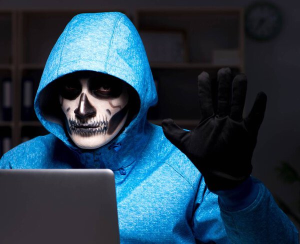 Scary hacker hacking security firewall late in office