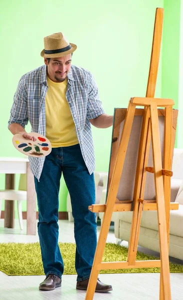Jovem artista masculino trabalhando em nova pintura em seu estúdio — Fotografia de Stock