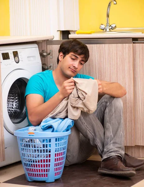 युवा पति आदमी घर पर कपड़े धो रहा है — स्टॉक फ़ोटो, इमेज