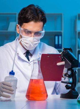 Kimya asistanı kimya laboratuvarında çalışıyor.
