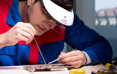 Bilgisayar uzmanı gece geç saatlerde bilgisayarı tamir ediyor.