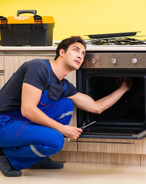 Joven contratista de servicio ensamblando muebles de cocina —  Fotos de Stock