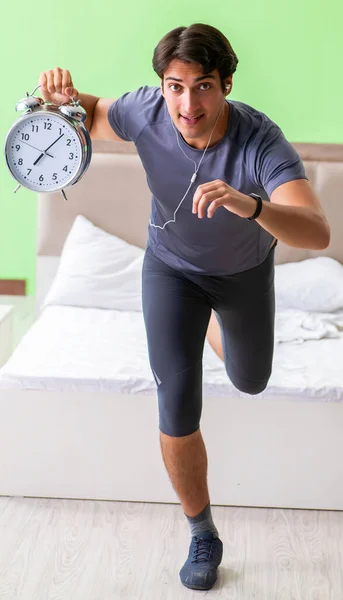 Jovem bonitão fazendo exercícios matinais no quarto do hotel — Fotografia de Stock