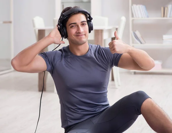 Adam evde spor yapıyor ve müzik dinliyor. — Stok fotoğraf