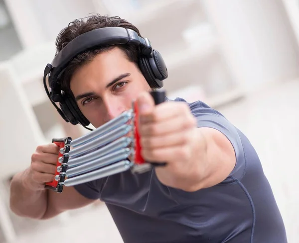 Homem fazendo esportes com banda de resistência e ouvindo música — Fotografia de Stock