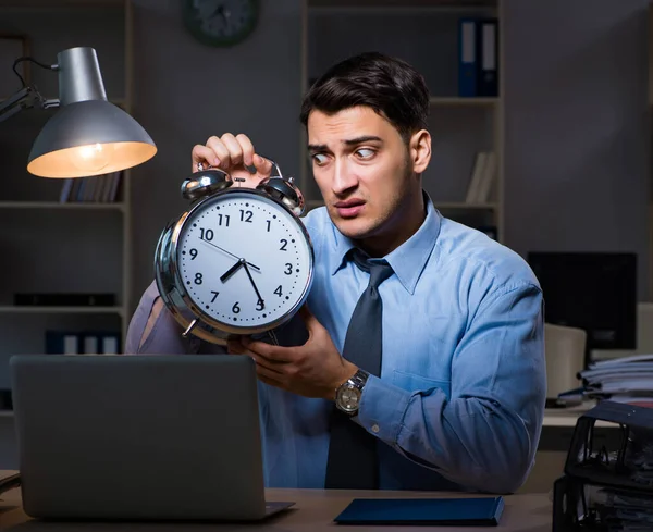 Jovem empregado que trabalha horas extras para cumprir prazo — Fotografia de Stock