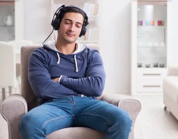 Jongeman die thuis naar muziek luistert — Stockfoto