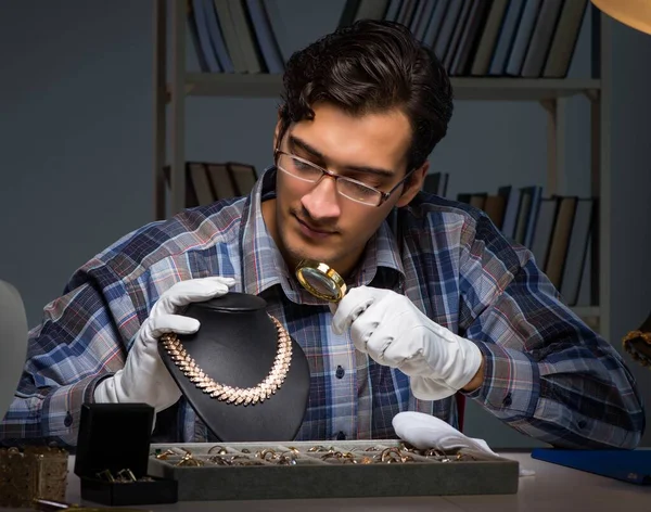 Junger Juwelier arbeitet nachts in seiner Werkstatt — Stockfoto