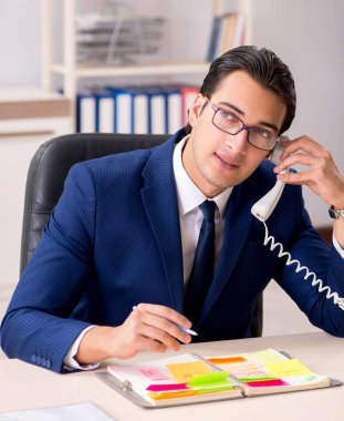 Çalışmalarını planlayan genç yakışıklı bir çalışan.