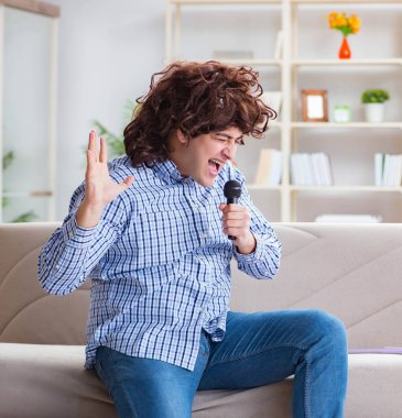 Evde karaoke yapan komik adam.