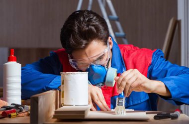 Genç adam ahşap parçaları DIY konseptinde yapıştırıyor.