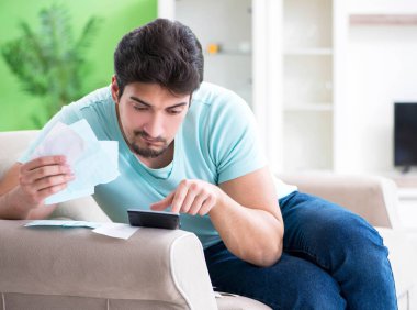 Genç adam kişisel finans ve faturalarla boğuşuyor.