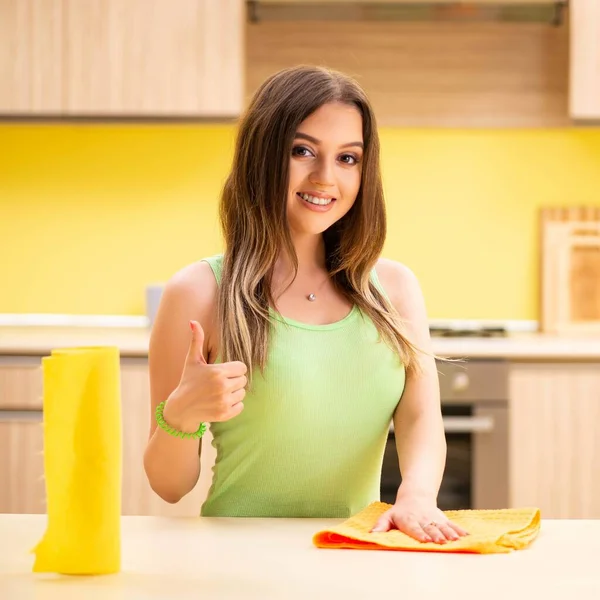 Jovem mulher beatifull polimento mesa na cozinha — Fotografia de Stock