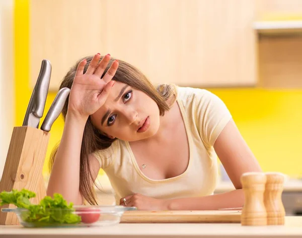 Junge Frau bereitet Salat zu Hause in Küche zu — Stockfoto