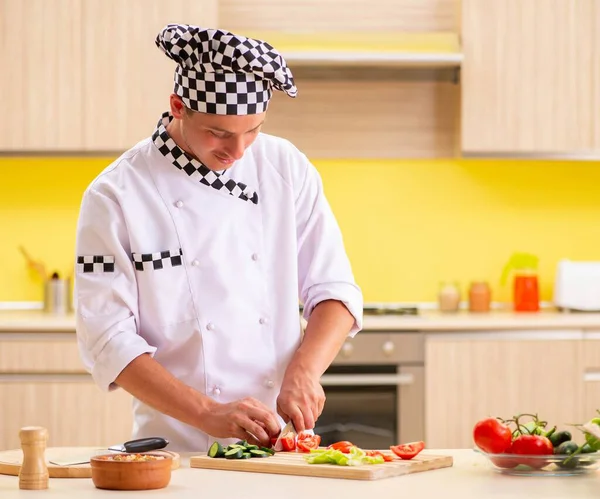 Jovem cozinheiro profissional preparando salada na cozinha — Fotografia de Stock