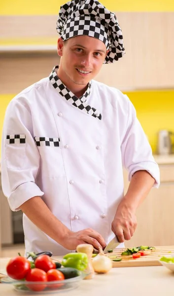 Jovem cozinheiro profissional preparando salada na cozinha — Fotografia de Stock