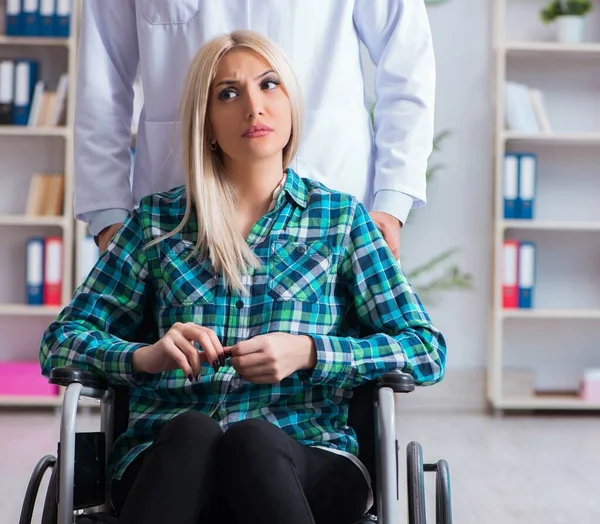 Mujer discapacitada en silla de ruedas visitando al médico hombre —  Fotos de Stock