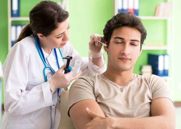 Female doctor checking patients ear during medical examination