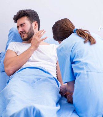 Kadın doktor erkek hastayı hastanede muayene ediyor.
