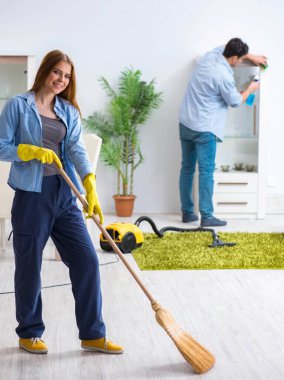 Genç bir aile evi temizliyor.