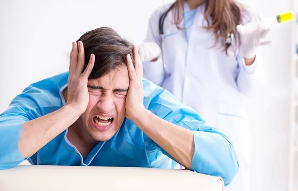 Funny man getting ready for buttocks syringe shot — Stock Photo, Image