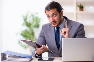 Genç işadamı ofiste oturuyor.