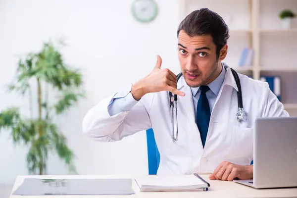 Jonge mannelijke knappe arts werkzaam in de kliniek — Stockfoto