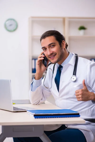 Joven hombre guapo médico que trabaja en la clínica — Foto de Stock