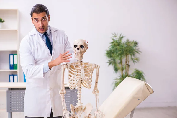 Молодой врач со скелетом — стоковое фото