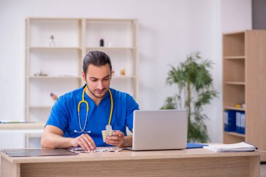 Klinikte çalışan genç erkek doktor.