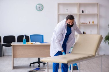 Genç erkek müteahhit salgın konseptinde dezenfekte kliniği