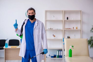 Genç erkek müteahhit salgın konseptinde dezenfekte kliniği