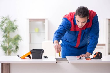 Genç erkek marangoz içeride çalışıyor.