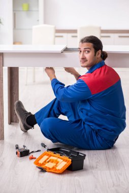 Genç erkek marangoz içeride çalışıyor.