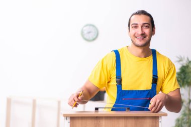 Genç erkek marangoz içeride çalışıyor.