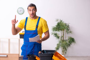 Genç erkek marangoz içeride çalışıyor.