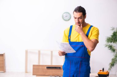 Genç erkek marangoz içeride çalışıyor.