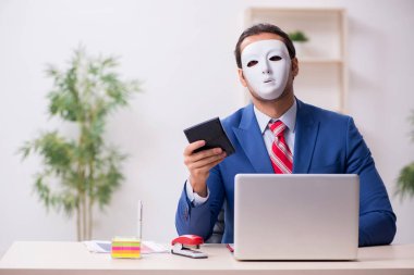 İkiyüzlülük konseptinde maske takan erkek çalışan.