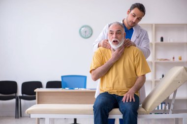 Yaşlı boynu yaralı bir adam genç erkek doktoru ziyaret ediyor.
