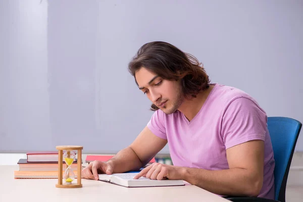 Joven estudiante masculino en el aula en el concepto de gestión del tiempo —  Fotos de Stock