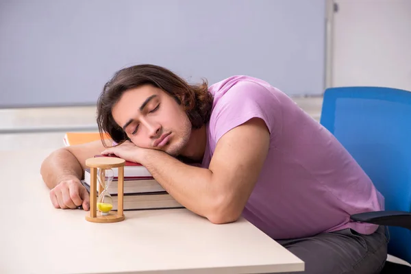 Young male student in the classroom at time management concept — Stock Photo, Image