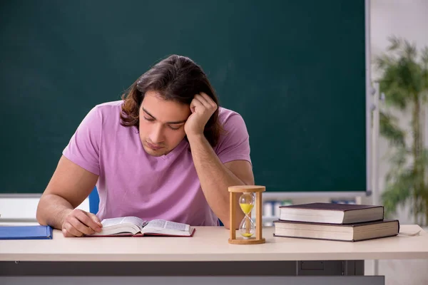 Ung manlig student i klassrummet vid tidpunkten management koncept — Stockfoto