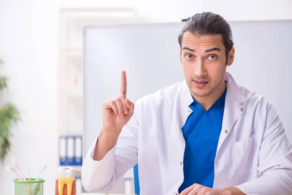 Jonge mannelijke tandarts werkzaam in de kliniek — Stockfoto