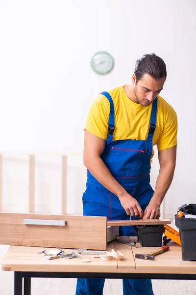 Joven carpintero masculino trabajando en interiores — Foto de Stock