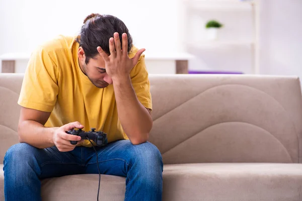 Jovem jogando joystick jogos em casa — Fotografia de Stock