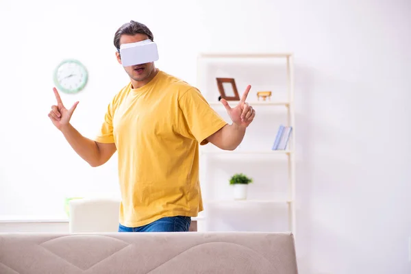 Jovem com óculos de realidade virtual em casa — Fotografia de Stock