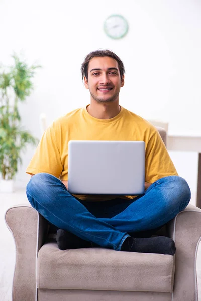 Young handsome man with computer at home