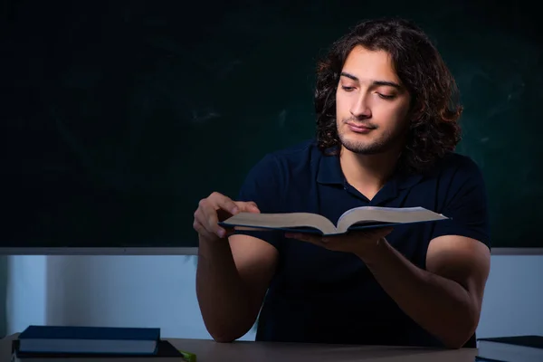 Ung manlig elev i klassrummet på natten — Stockfoto