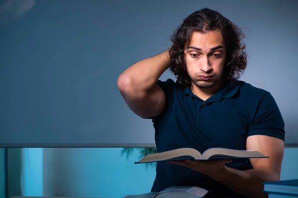 Joven estudiante masculino en el aula por la noche —  Fotos de Stock