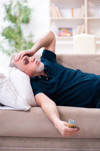 Vieil homme aux yeux blessés se reposant à la maison — Photo